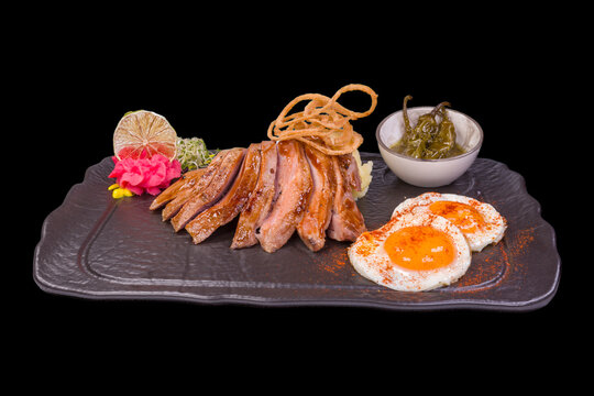 Delicious turkey fillets teriyaki in a stone plate, with reflection,