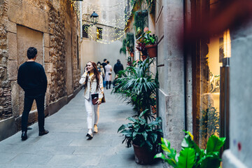 Cheerful woman speaking on phone and walking on street