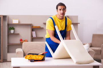 Young male contractor repairing chair at home