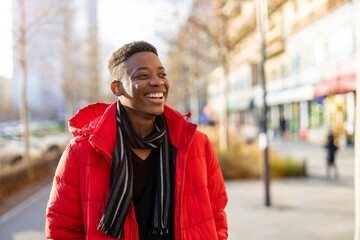 Portrait of a young man standing in a city street, smiling
