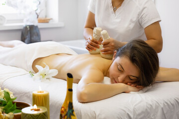 Obraz na płótnie Canvas Young adult woman enjoying body massage at spa club