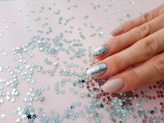 Beautiful female hand with Christmas nail design on pink background. Nail design, manicure with clock pattern. Shellac, gel polish.