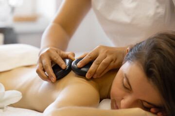 Obraz na płótnie Canvas Massage with hot stones at spa salon