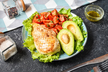 Caprese lunch bowl with grilled chicken and avocado on stone background