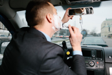 Businessman shaving in car by razor and foam at the wheel. Shaving man in the driver's seat....