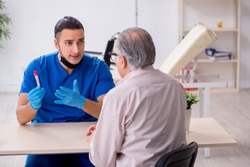 Old patient visiting young male doctor in blood sampling concept
