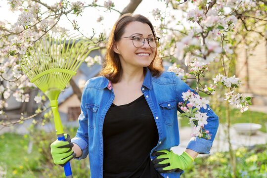 Spring gardening, portrait of mature smiling woman with rake