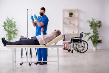 Old patient visiting young male doctor for intravenous therapy