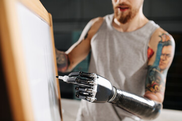Image of a cyborg man with bionic hand writing on a board with a permanent marker. Cropped, no...