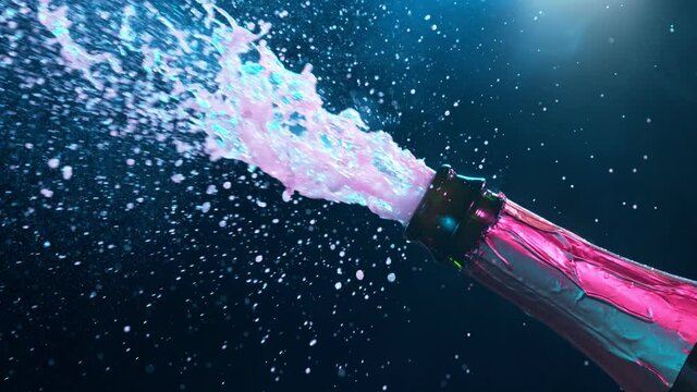 Super slow motion of Champagne explosion with flying cork closure, neon colors, opening champagne bottle closeup.