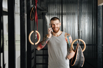 Young disabled armless man speaking on the phone, taking a break while training in the gym....