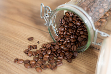 Coffee beans falling out of a glass jar close-up, top down view, rustic style, interior kitchen design, retro, warm tones