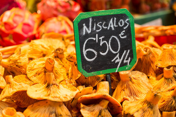 Hotizontal detail of indoor market sign in handwritten Spanish selling Níscalos, or Lactarius...