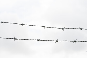 Barbed or barb wire fence against sky