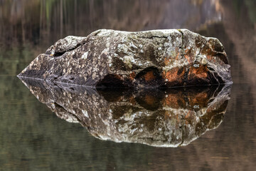 Rock reflection in a still wintry lake. Snowdonia, Wales.