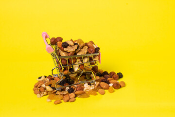 nut mix in a supermarket basket on a yellow background