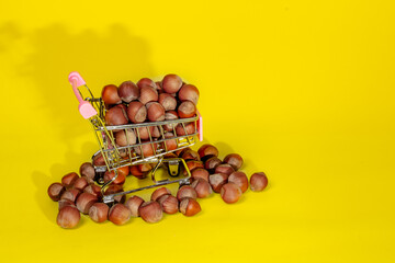 hazelnuts in a supermarket basket on a yellow background
