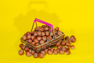 hazelnuts in a supermarket basket on a yellow background