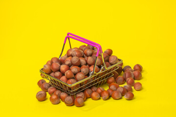 hazelnuts in a supermarket basket on a yellow background
