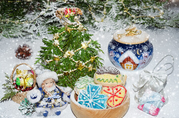 Homemade cookies and a small toy snow maiden on the background of Christmas decorations and snow. selective focus