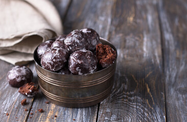 Soft vegan steamed chocolate gingerbread cookies with icing sugar in vintage bowl on wooden table, free space