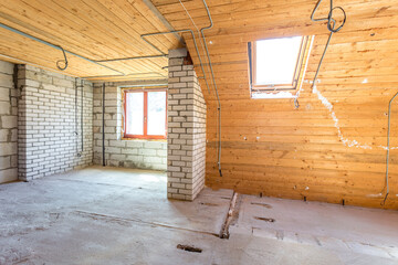 Fototapeta na wymiar empty interior in house without repair on wooden mansard floor and brick wall