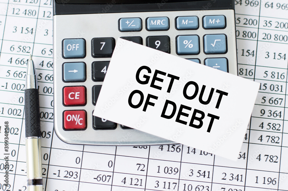 Poster card with text get out of debt and calculator with pen on office desk
