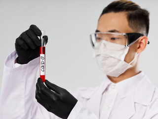 Male laboratory assistants in a white coat holds a test of research technology