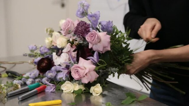 girl florist prepares flowers for making a bouquet of flowers