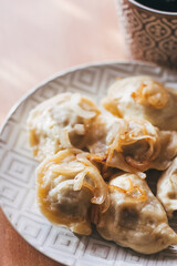 Dumplings, filled with meat and served with fried onion and meat pieces. Varenyky, vareniki, pierogi, pyrohy. Dumplings with filling.