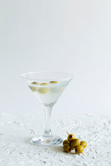 martini with olives. Martini glass with cocktail and olives on white background. Cocktail Margarita with ice on the table. copy space. alcohol drinks. vertical.