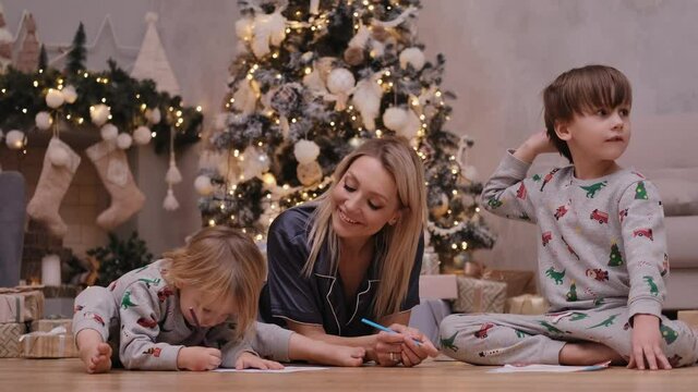 Happy woman with children write letters to Santa Claus before Christmas. Family concept