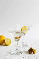 Two Martini glasses with cocktail and olives on white background. Cocktail Margarita with lime and lemon on the table. copy space. alcohol drinks. vertical.