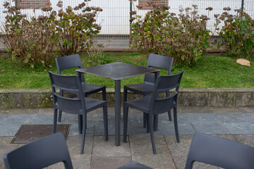 Mesas y sillas vacias en una terraza de un bar