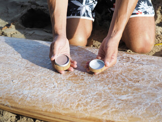 Surfer holds in hands sunscreen for face. Close-up shot.