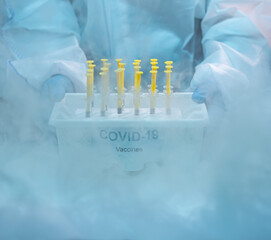 Medical staff distributing covid-19 vaccine tray inside the freezer. Healthcare and medical concept