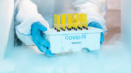 Medical staff distributing covid-19 vaccine tray inside the freezer. Healthcare and medical concept