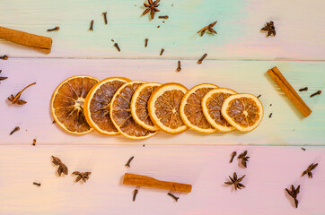 Set for mulled wine on a rainbow background, scattered dry oranges, cinnamon, cloves, star anise,...