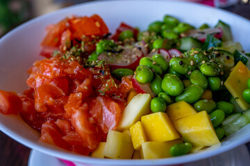 Salmon poke with avocado and mango, seaweed, pickled carrots, cucumber