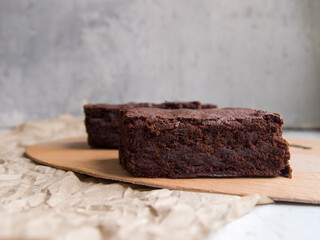 Appetizing homemade brownies. Slices of delicious dark chocolate cake on a wooden board on a...