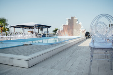 Glass chairs stand in a row in a beautiful wedding outing ceremony