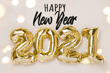 Happy New Year celebration. Gold foil balloons numeral 2021, party decoration and confetti stars on beige background