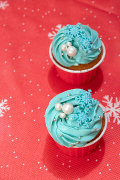 Two cupcakes with blue cream, beads and snowflakes. The view from the top. Selective focus. © Natali Mali