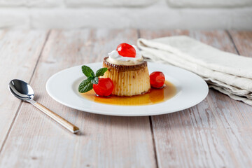 Egg flan with cream, cherries and mint