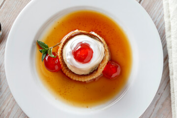 Egg flan with cream, cherries and mint