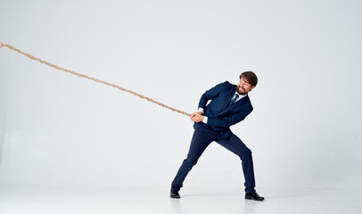 man with rope in hand on light background business finance advertising model