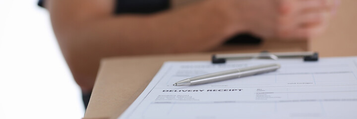 Close up of deliver man standing by cardboard box with pen and delivery receipt