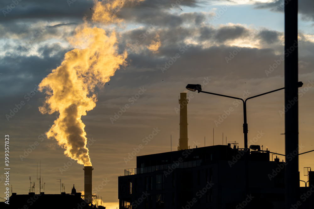 Wall mural factory chimneys against the setting sun.