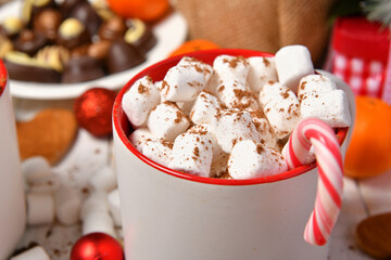 sweet food top view background for merry christmas or new year holiday decoration - chocolate candies, tangerines, cookies, marshmallow and cocoa latte on white wood