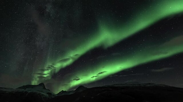 Auroras above snow covered mountains, static shot without movement